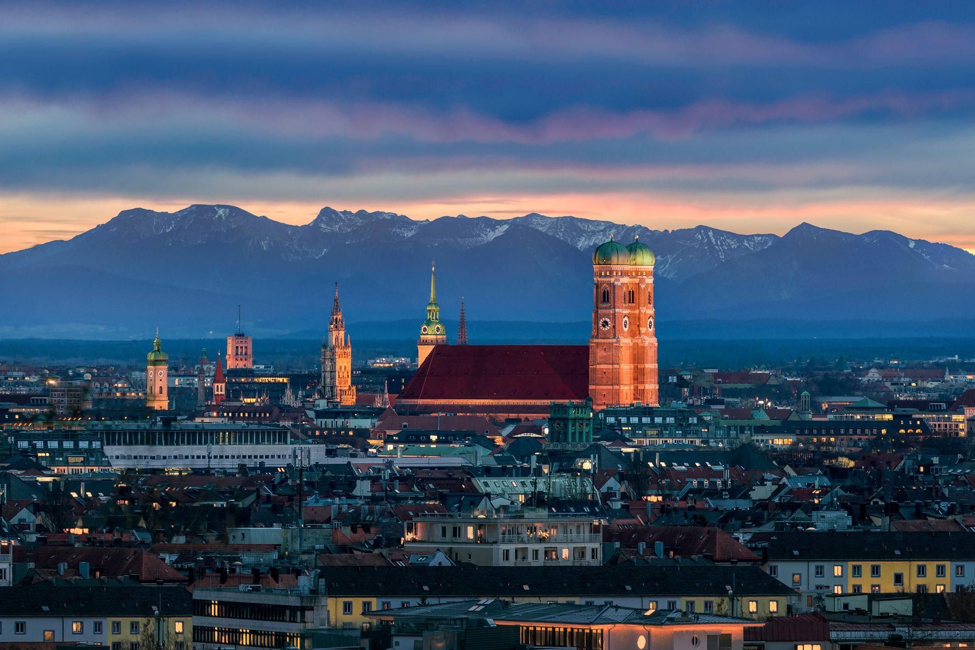 Blick auf die Altstadt von München mit Frauenkirche und Alpen im Hintergrund – idealer Einstieg für ein Wochenende mit Escort Muenchen.
